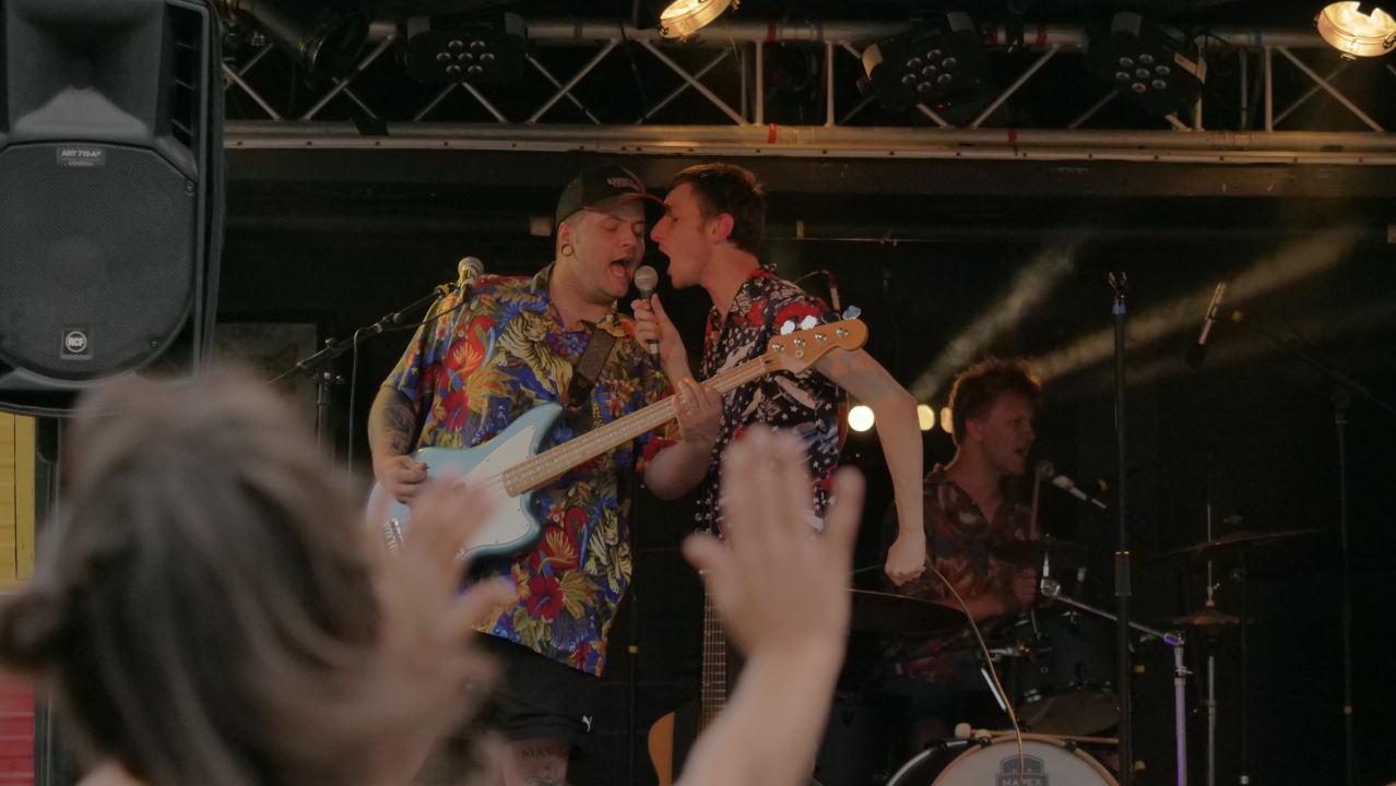 Photo du bassiste et du chanteur d'Excellento avec le batteur en arrière-plan