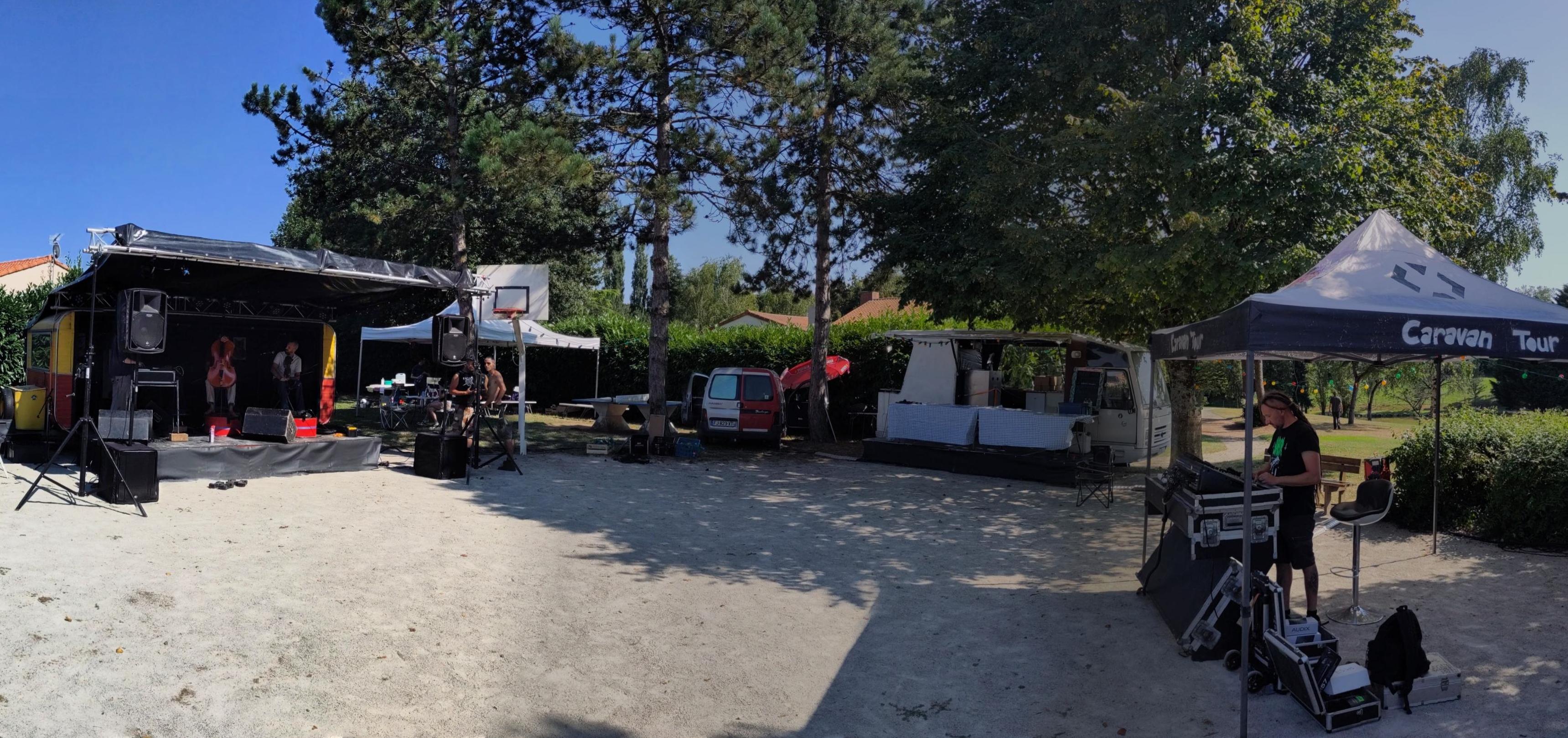Photo d'ensemble de la scène caravane, du camion-bar et de la régie du Caravan Tour un terrain de pétanque