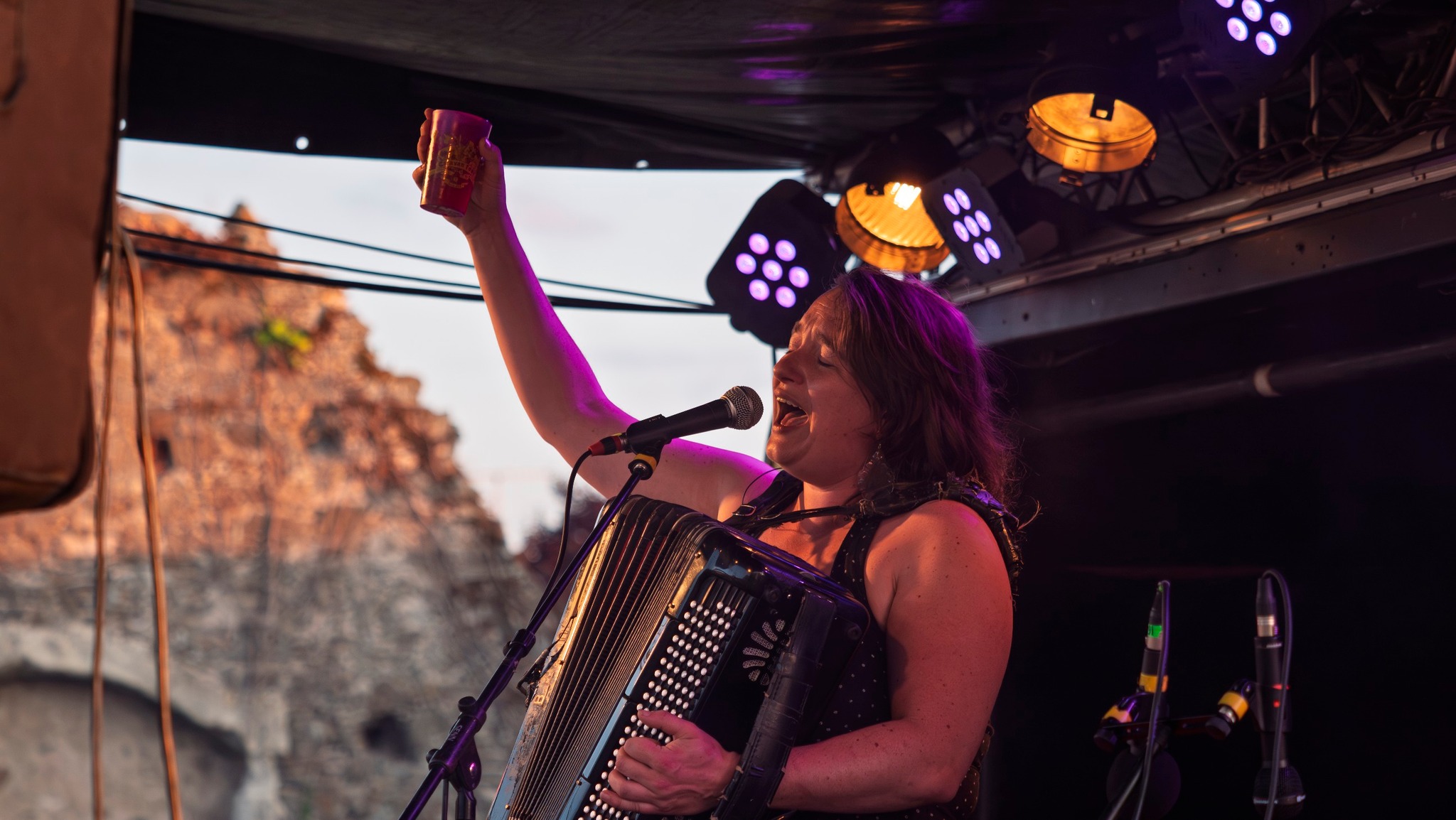 Émeline tout court à l'accordéon, un verre à la main