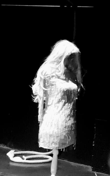 Image sombre en noir et blanc, on distingue une silhouette de mannequin avec une perruque